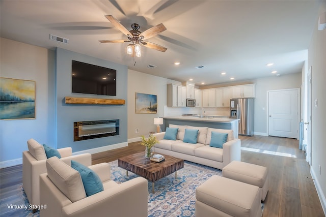 living room featuring hardwood / wood-style floors and ceiling fan