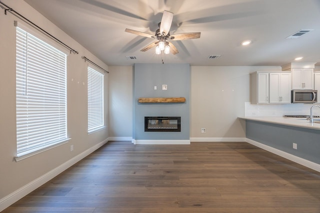 321 Baker Dr, Plano, TX 75074 - unfurnished living room with a large fireplace, dark wood-style floors, recessed lighting, a ceiling fan, and baseboards