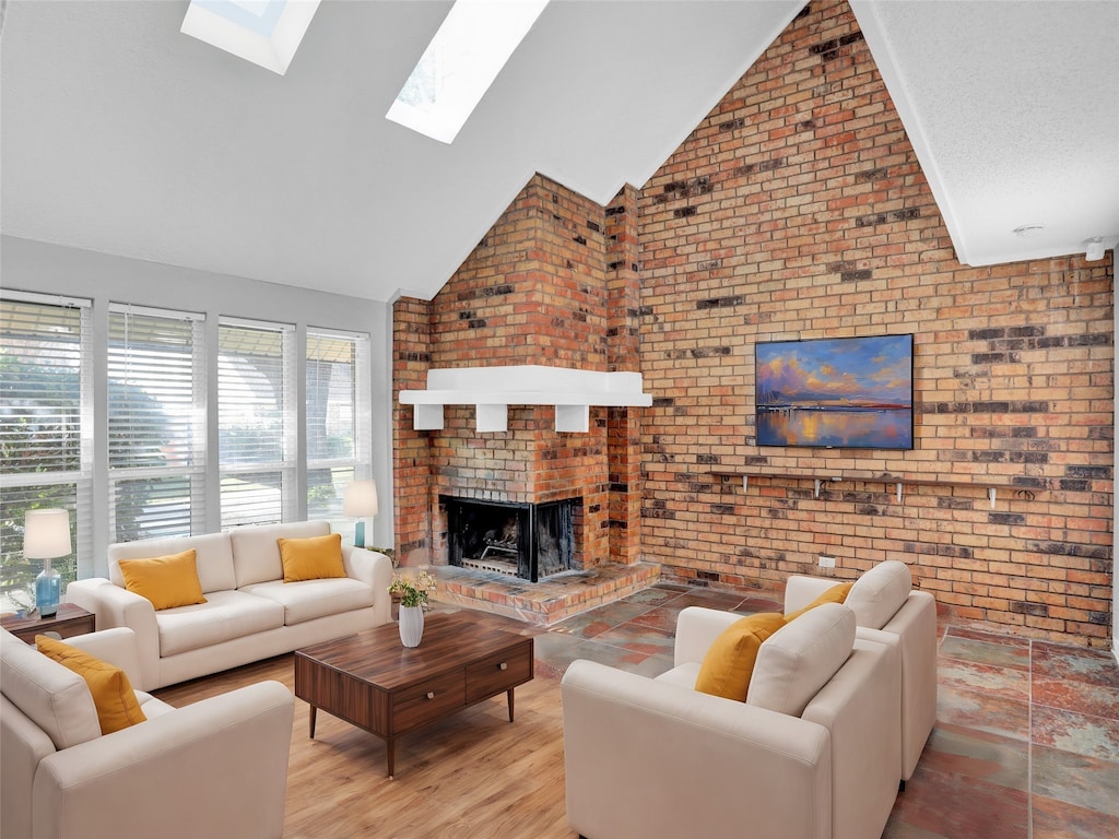 living room featuring high vaulted ceiling, light wood-type flooring, a fireplace, and brick wall