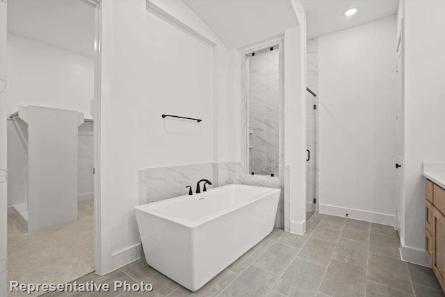 bathroom featuring tile patterned floors, vanity, and a tub to relax in