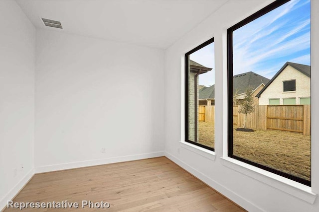 empty room featuring hardwood / wood-style flooring and a healthy amount of sunlight