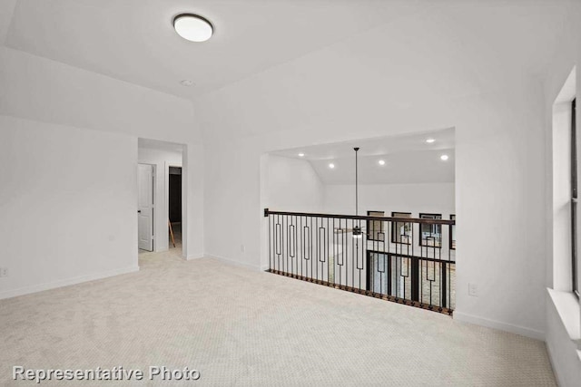 empty room featuring carpet floors and vaulted ceiling