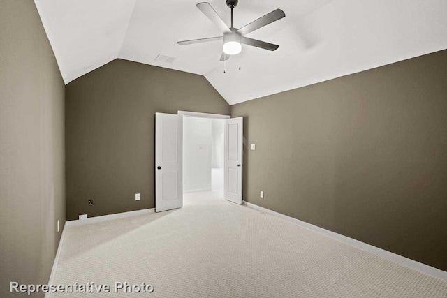 unfurnished bedroom with ceiling fan, light colored carpet, and vaulted ceiling