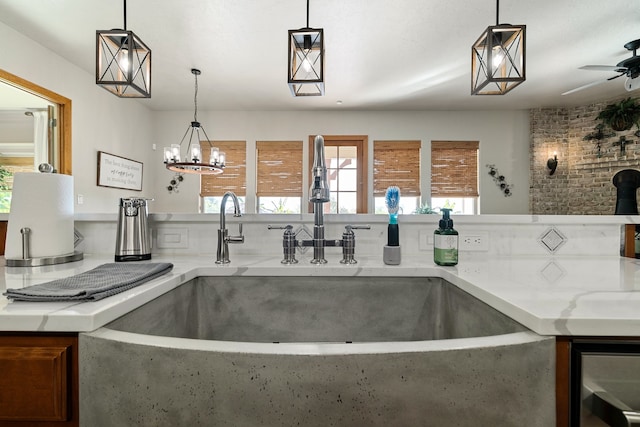 kitchen featuring wine cooler, sink, and hanging light fixtures