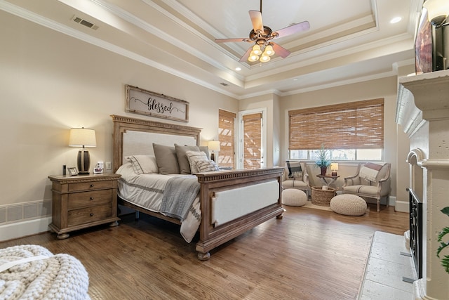 bedroom featuring a tray ceiling, ceiling fan, and wood-type flooring