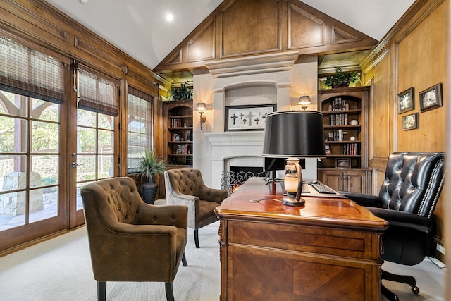 carpeted office space with built in shelves, wooden walls, and high vaulted ceiling