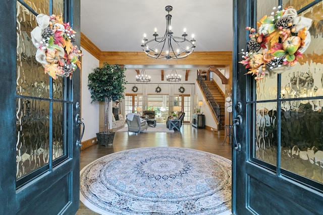 entrance foyer featuring crown molding, hardwood / wood-style floors, and a chandelier