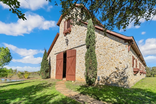 view of outbuilding with a yard and a water view