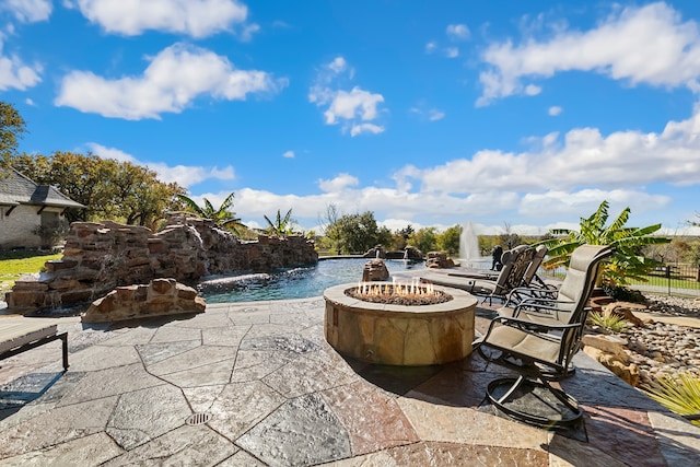 view of patio / terrace with pool water feature and an outdoor fire pit