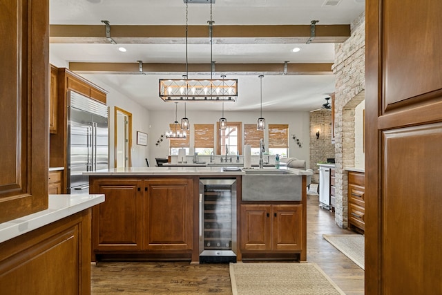 bar featuring beverage cooler, dark wood-type flooring, beamed ceiling, hanging light fixtures, and built in fridge