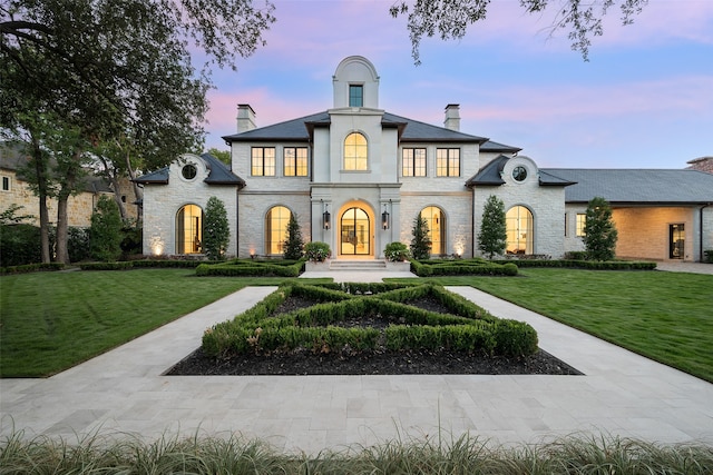 french country style house with french doors and a lawn