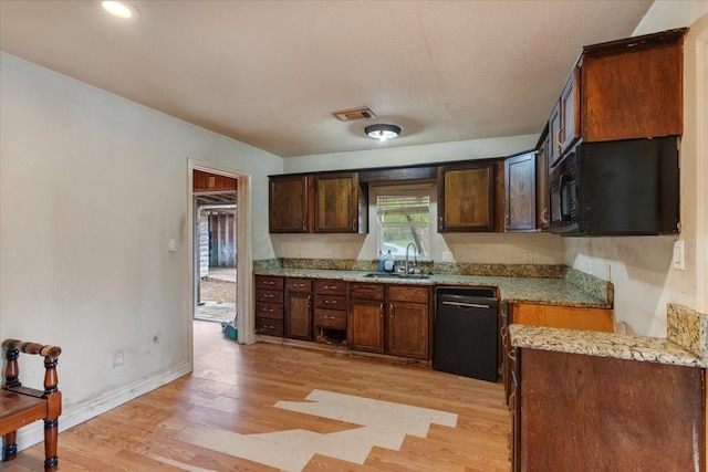 kitchen with light stone countertops, dishwasher, light wood-type flooring, and sink