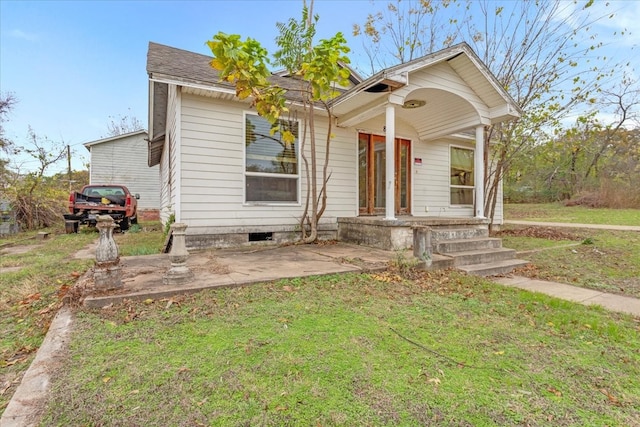 bungalow-style house with a front lawn and covered porch