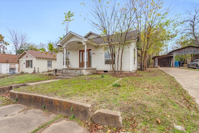 bungalow with a front lawn and covered porch