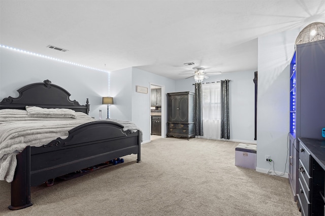 bedroom with carpet flooring, ceiling fan, and ensuite bath