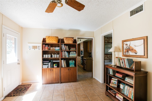 interior space with ceiling fan, light tile patterned flooring, crown molding, and a textured ceiling