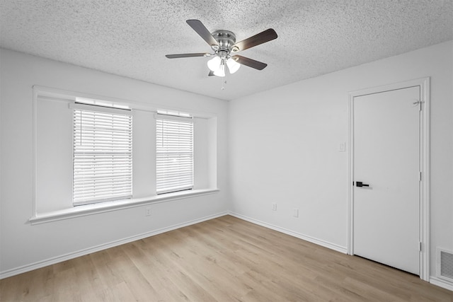 spare room with ceiling fan, a textured ceiling, and light hardwood / wood-style flooring