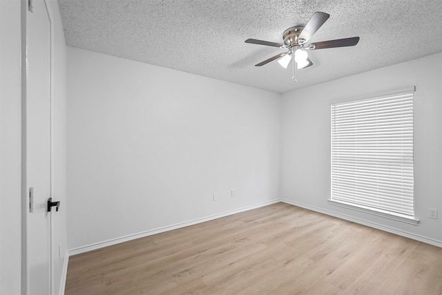 spare room featuring ceiling fan, a textured ceiling, and light wood-type flooring