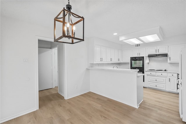 kitchen featuring decorative light fixtures, white cabinetry, kitchen peninsula, and light hardwood / wood-style flooring