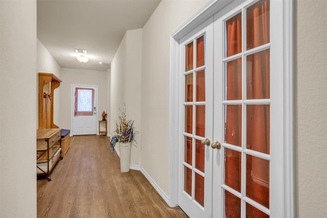 corridor with french doors and hardwood / wood-style flooring