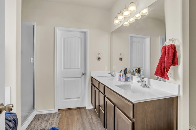 bathroom with vanity, a shower with shower door, and hardwood / wood-style flooring