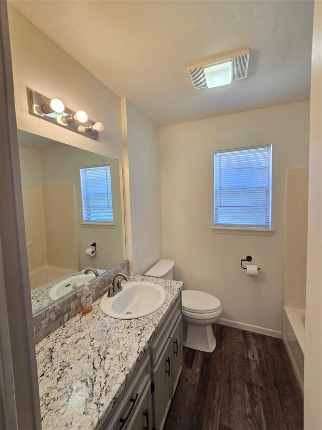 bathroom featuring toilet, vanity, and hardwood / wood-style floors