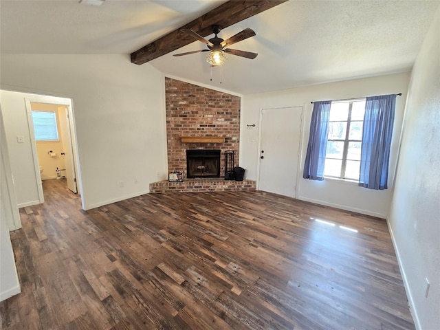 unfurnished living room featuring a textured ceiling, dark hardwood / wood-style floors, a brick fireplace, ceiling fan, and vaulted ceiling with beams