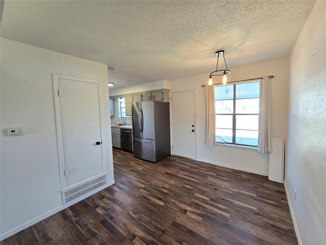 kitchen featuring dishwasher, hanging light fixtures, stainless steel fridge, dark wood-type flooring, and a textured ceiling