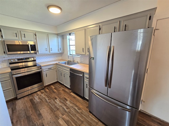 kitchen with stainless steel appliances, backsplash, dark hardwood / wood-style flooring, and sink