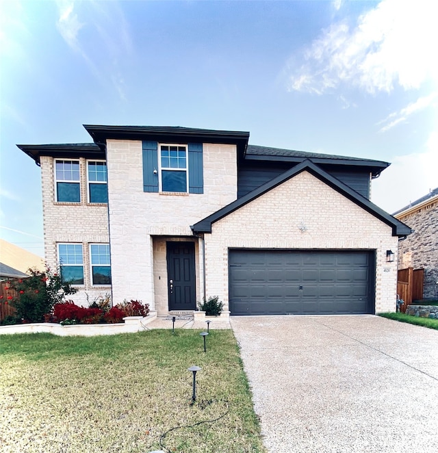 view of property featuring a garage and a front lawn