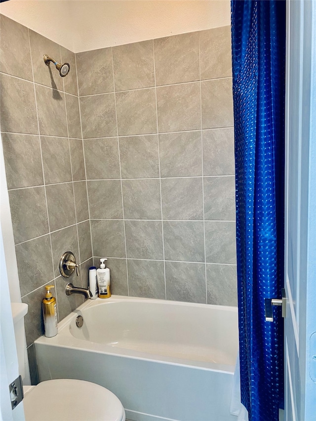 bathroom with shower / tub combo with curtain and toilet