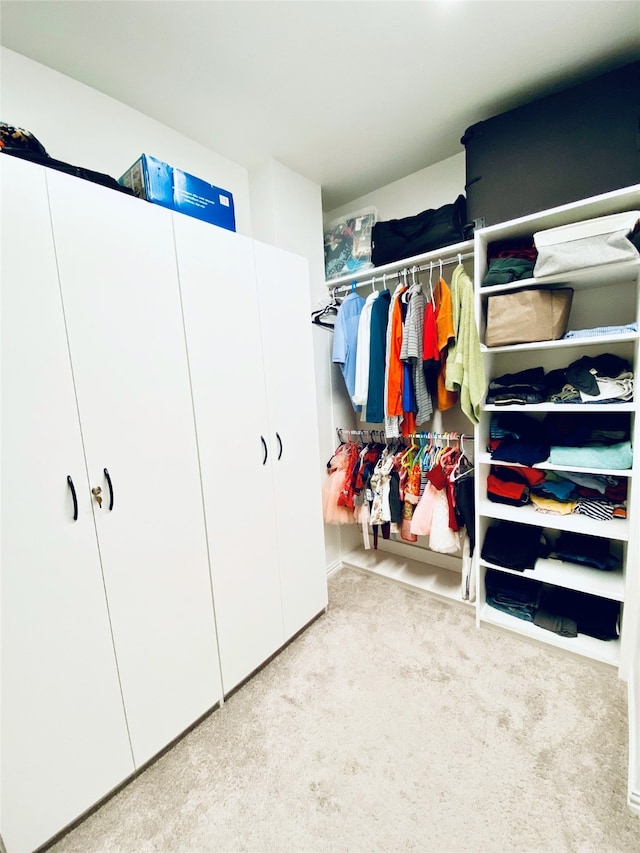 walk in closet featuring light carpet