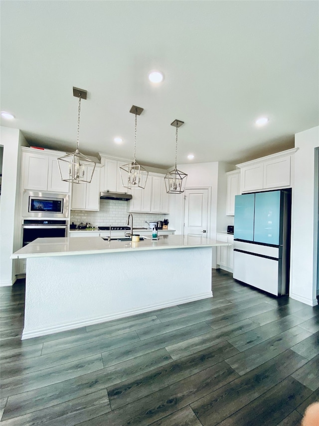 kitchen featuring pendant lighting, dark hardwood / wood-style flooring, white cabinetry, and stainless steel appliances