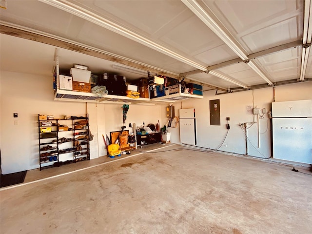 garage featuring electric panel and white refrigerator