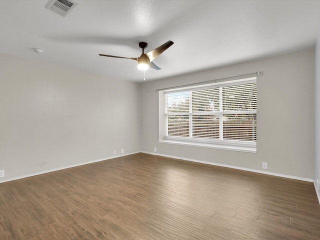 unfurnished room with ceiling fan and dark hardwood / wood-style flooring