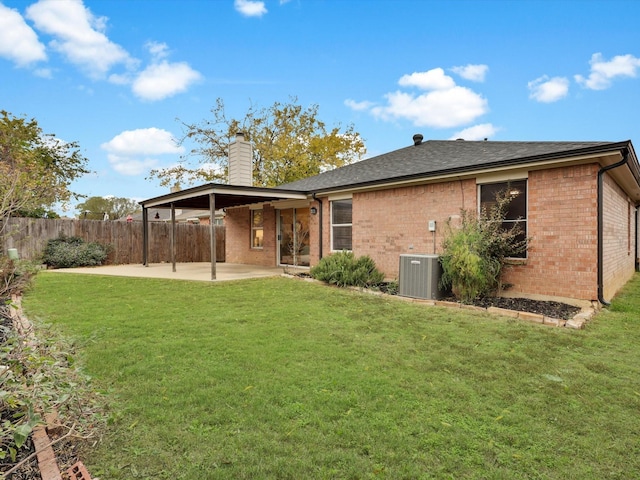 back of property featuring central AC unit, a yard, and a patio