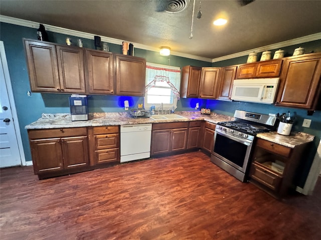 kitchen featuring light stone counters, ornamental molding, white appliances, dark wood-type flooring, and sink