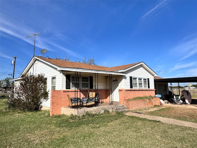 view of front of home featuring a carport, a porch, and a front yard