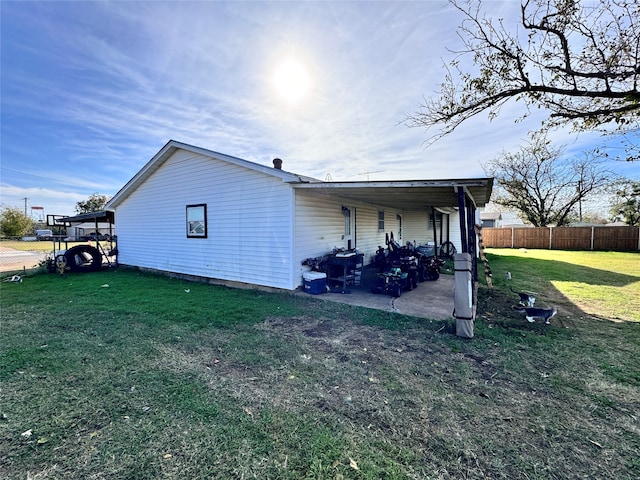 view of side of property featuring a lawn and a patio area