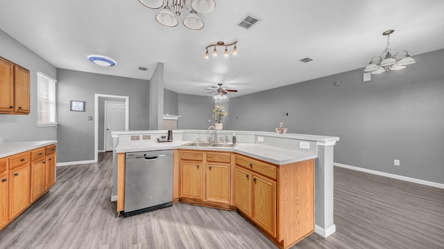 kitchen featuring a kitchen island with sink, a sink, visible vents, light countertops, and dishwasher