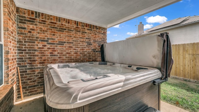 view of patio / terrace featuring a hot tub and fence