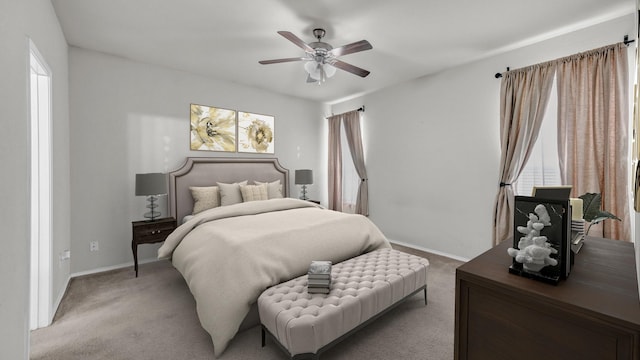 bedroom with light carpet, a ceiling fan, and baseboards