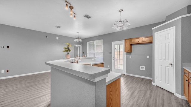 kitchen featuring a chandelier, visible vents, light wood finished floors, and a large island