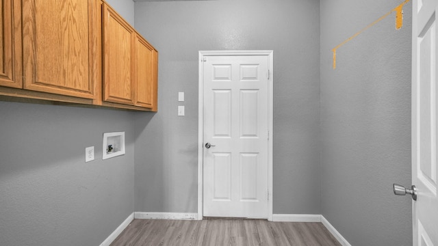 laundry area with baseboards, cabinet space, washer hookup, and light wood finished floors