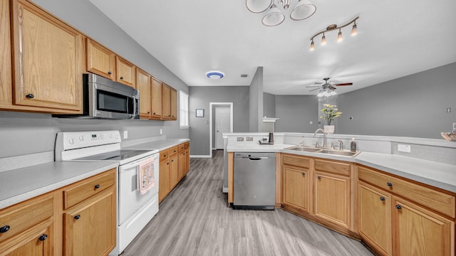 kitchen featuring a sink, stainless steel appliances, light wood-style floors, light countertops, and ceiling fan