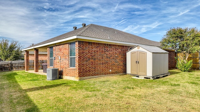 view of side of property featuring an outbuilding, a storage unit, a fenced backyard, and a yard