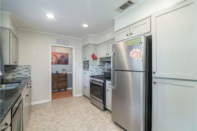 kitchen featuring decorative backsplash, ornamental molding, stainless steel appliances, and dark stone counters