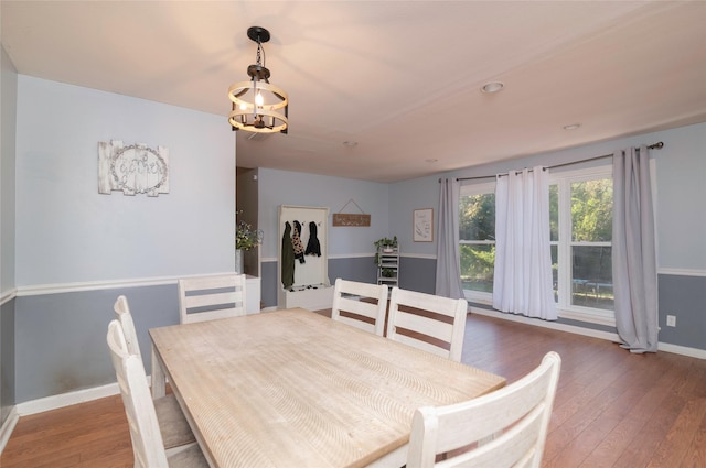 dining area with dark hardwood / wood-style flooring and a notable chandelier