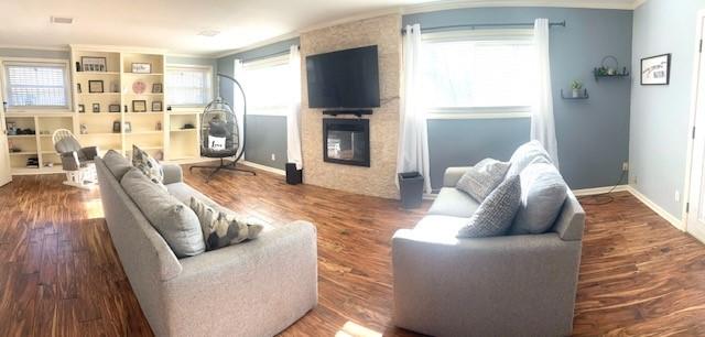 living room with a fireplace, crown molding, and hardwood / wood-style floors