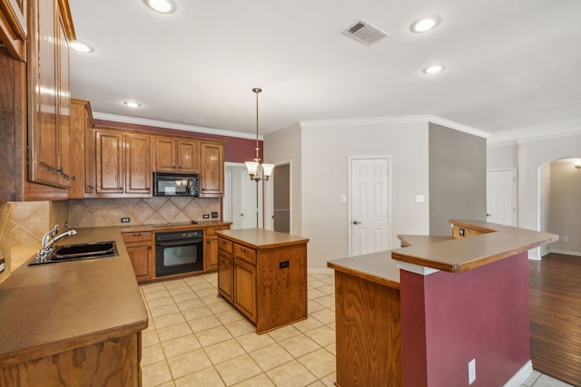 kitchen featuring a center island, black appliances, sink, ornamental molding, and decorative light fixtures